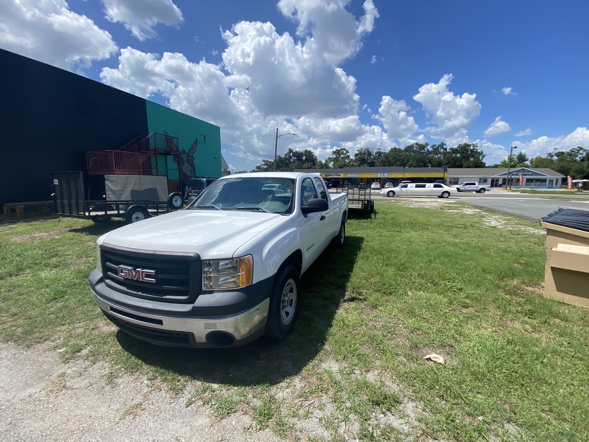 Daniel's Junk Removal white GMC pickup and hauling trailer ready for a Tampa Bay job